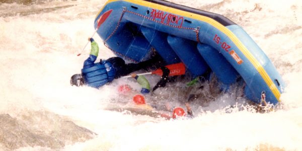 group of rafters falling in the water as their raft flips over