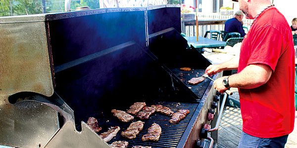 Man cooking steaks on an outdoor grill