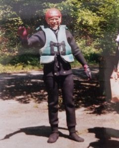 man in life vest and red helmet waiving to the camera