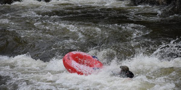 person in the river after falling off the tube